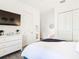 Bedroom with white dresser, TV, and walk in closet at 8731 Sanders Tree Loop, Wesley Chapel, FL 33545