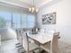 Bright dining room with white table and chairs, and modern chandelier at 8731 Sanders Tree Loop, Wesley Chapel, FL 33545