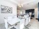 Modern dining room with white table and chairs, open to the kitchen at 8731 Sanders Tree Loop, Wesley Chapel, FL 33545