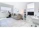 Bright exercise room with a stationary bike, sofa, and a large TV at 8731 Sanders Tree Loop, Wesley Chapel, FL 33545