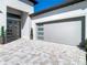 Attached garage with modern door and paver driveway at 8731 Sanders Tree Loop, Wesley Chapel, FL 33545