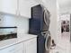 Modern laundry room with stacked washer and dryer, and additional storage at 8731 Sanders Tree Loop, Wesley Chapel, FL 33545