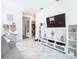 Open living area with white built-ins, a large TV, and white flooring at 8731 Sanders Tree Loop, Wesley Chapel, FL 33545
