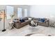Modern living room with a large sectional sofa and marble flooring at 8731 Sanders Tree Loop, Wesley Chapel, FL 33545
