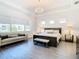 Main bedroom with king bed, sitting area, and large windows at 8731 Sanders Tree Loop, Wesley Chapel, FL 33545