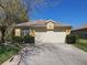 House exterior featuring a two-car garage and well-manicured lawn at 11445 Bathgate Ct, New Port Richey, FL 34654