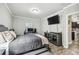 A bedroom with a TV, desk, modern gray walls, and stylish wood-look floors at 12613 Longstone Ct, New Port Richey, FL 34655