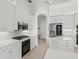 Modern kitchen with white cabinets, stainless steel appliances and large island at 7925 Royal Queensland Way, Lakewood Ranch, FL 34202