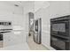 Modern kitchen with white cabinets, stainless steel appliances and island at 7925 Royal Queensland Way, Lakewood Ranch, FL 34202