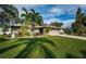 Inviting home featuring a well-maintained lawn, mature trees, and a two-car garage at 2342 Hazelwood Ln, Clearwater, FL 33763