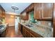 Kitchen featuring granite counters, wood cabinets, laminate flooring, and stainless steel appliances at 2342 Hazelwood Ln, Clearwater, FL 33763