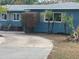 Side view of a charming blue house with mature palm trees and landscaping at 2716 Miriam S St, Gulfport, FL 33711