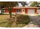 Red brick ranch home with a white garage door and a well-manicured lawn at 468 Limewood Ave, Dunedin, FL 34698