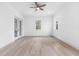 Light-filled bedroom with wood-look floors and access to a balcony at 7306 Exter Way, Tampa, FL 33615