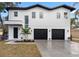 Modern two-story home with three-car garage and landscaped yard at 7306 Exter Way, Tampa, FL 33615