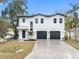 Modern white two-story house with a three-car garage at 7306 Exter Way, Tampa, FL 33615