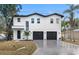 Modern white two-story house with a three-car garage at 7306 Exter Way, Tampa, FL 33615