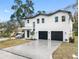 Modern two-story home with three-car garage and driveway at 7306 Exter Way, Tampa, FL 33615