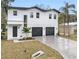 Modern two-story home with three-car garage and landscaped front yard at 7306 Exter Way, Tampa, FL 33615