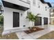 Modern home's front entrance with black door and landscaping at 7306 Exter Way, Tampa, FL 33615