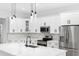 Modern kitchen with white cabinets, stainless steel appliances and a quartz island at 7306 Exter Way, Tampa, FL 33615