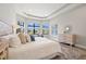 Bright main bedroom with large windows, wood floors, tray ceiling, and neutral color palette at 10111 Craftsman Park Way, Palmetto, FL 34221