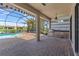 Screened outdoor kitchen with a built-in grill, sink, and bar area, plus a swimming pool and a water view at 10111 Craftsman Park Way, Palmetto, FL 34221