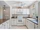 Bright white kitchen with stainless steel appliances and granite countertops at 17710 Long Point Dr, Redington Shores, FL 33708