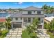 Modern home with water access, showcasing a metal roof and expansive driveway at 7949 2Nd S Ave, St Petersburg, FL 33707