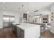 Open concept kitchen island with white quartz countertop, stainless steel appliances, and hardwood floors at 7949 2Nd S Ave, St Petersburg, FL 33707