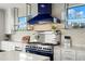 Modern kitchen features blue range hood and white shaker cabinets at 7949 2Nd S Ave, St Petersburg, FL 33707