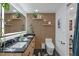 Modern bathroom featuring a stylish vanity with double sinks, a sleek toilet, and unique wood-slat wall at 1367 51St Ne Ave, St Petersburg, FL 33703