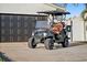 Pristine black golf cart is parked on a clean driveway in front of an attached garage at 1367 51St Ne Ave, St Petersburg, FL 33703