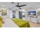 A bright main bedroom with a ceiling fan, access to a balcony, and modern entertainment setup at 1367 51St Ne Ave, St Petersburg, FL 33703