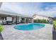 Private kidney shaped pool with an outdoor entertainment area, television, and patio furniture at 1367 51St Ne Ave, St Petersburg, FL 33703