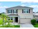 Two-story house with a two-car garage and landscaped lawn at 8277 Bower Bass Cir, Wesley Chapel, FL 33545