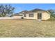 Home's backyard with dry grass and a view of a neighboring house at 10918 Ancient Futures Dr, Tampa, FL 33647