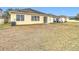 Home's backyard with dry grass and a view of a neighboring house at 10918 Ancient Futures Dr, Tampa, FL 33647