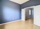 Blue bedroom with wood-look floors and view of another room at 10918 Ancient Futures Dr, Tampa, FL 33647