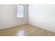 Bedroom with wood-look floors and a window with blinds at 10918 Ancient Futures Dr, Tampa, FL 33647