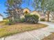 House exterior showcasing light yellow walls, a double-car garage, and landscaping at 10918 Ancient Futures Dr, Tampa, FL 33647