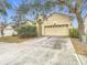 House exterior showcasing light yellow walls, a double-car garage, and landscaping at 10918 Ancient Futures Dr, Tampa, FL 33647