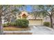 House exterior showcasing light yellow walls, a double-car garage, and landscaping at 10918 Ancient Futures Dr, Tampa, FL 33647