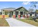 Charming craftsman style home with a green exterior, red brick accents, and a covered porch at 1518 E Knollwood St, Tampa, FL 33610