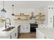 Modern kitchen with white cabinets, quartz countertops and floating shelves at 1518 E Knollwood St, Tampa, FL 33610