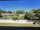 View of backyard with a white fence, trees, and neighboring houses at 3600 Magnolia Ridge Cir # 1221-G, Palm Harbor, FL 34684