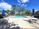 Community pool area with lounge chairs, tables, and umbrellas at 3600 Magnolia Ridge Cir # 1221-G, Palm Harbor, FL 34684