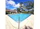 Community pool with lounge chairs and surrounding landscaping at 3600 Magnolia Ridge Cir # 1221-G, Palm Harbor, FL 34684