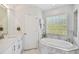 Bright bathroom featuring a soaking tub, vanity, and a unique glass block window at 6231 Bayshore Blvd, Tampa, FL 33611