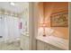 Well-lit bathroom features decorative wallpaper, single sink vanity and shower-tub combo at 6231 Bayshore Blvd, Tampa, FL 33611